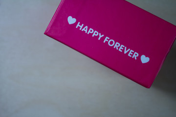 Valentines day background with pink gift box on wooden table. Top view with copy space.