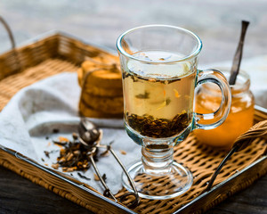 Herbal tea in a transparent mug on a tray