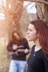 Young beautiful happy couple playing guitar and singing, selective focus