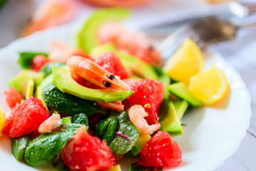 Salad with shrimps, avocado and grapefruit on a light background