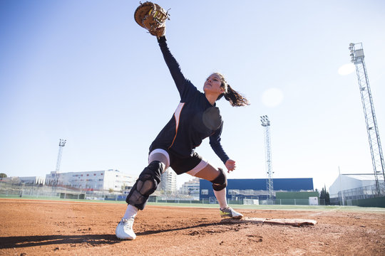 Female baseman catching the ball during a baseball game
