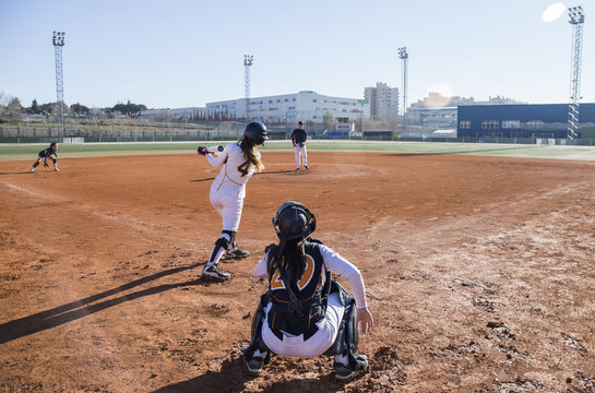 Female batter hitting the ball during a baseball game - Powered by Adobe
