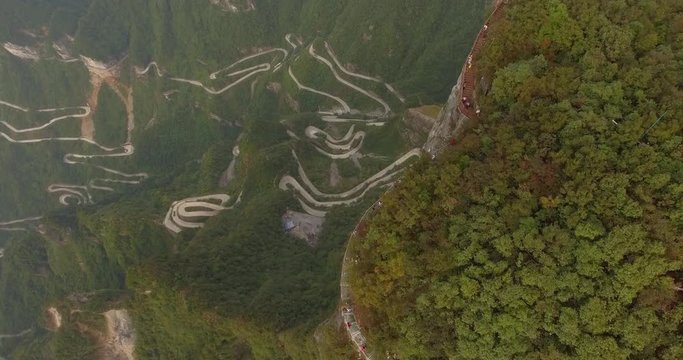 Famous glass walk top view and aerial shot of the long and windy 99 turn road going up to the summit of Tianmen shan in mountain national park, Hunan province, China.