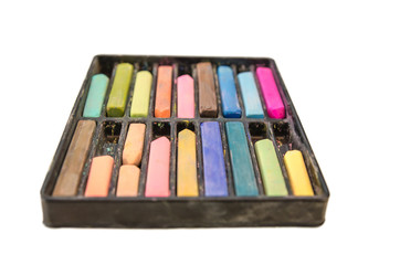 Multi-colored chalk on white background.