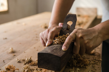 The carpenter was working furniture wood in studio