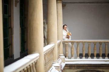 Fototapeta na wymiar Beautiful and gentle bride standing on balcony alone