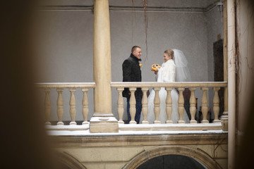 Beautiful groom and bride standing on balcony together