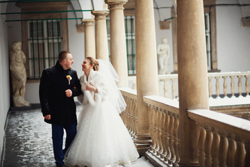 Beautiful groom and bride walking on balcony together