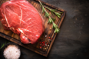 A large piece of beef chop on a cutting board. raw meat.