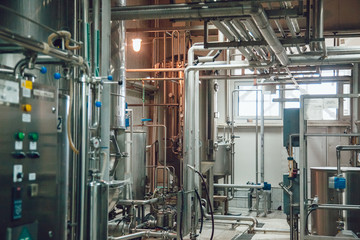Modern beer plant, with brewing kettles, vessels, tubs and pipes made of stainless steel. Brewery.