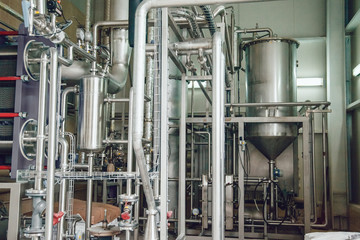 Modern beer plant, with brewing kettles, vessels, tubs and pipes made of stainless steel. Brewery.