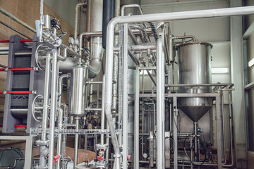 Modern beer plant, with brewing kettles, vessels, tubs and pipes made of stainless steel. Brewery.