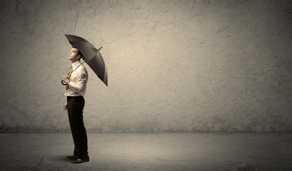 Handsome business man holding umbrella with copy space backgroun