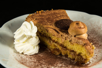 Torta di pasticceria con panna su sfondo nero