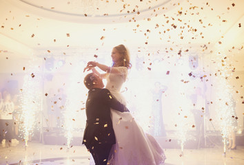 Happy beautiful newlyweds dancing in the restaurant