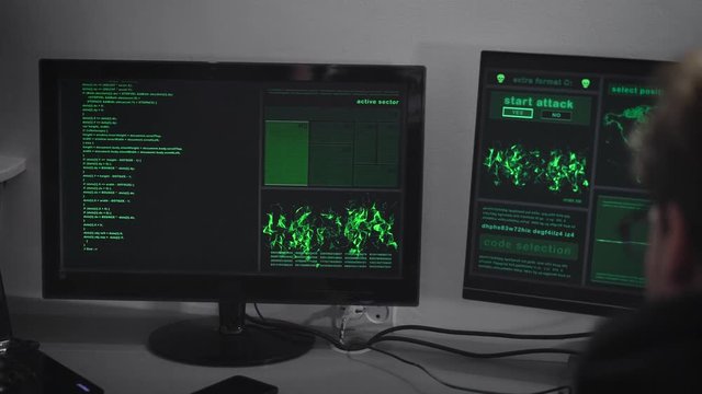 Hacker Company. A hacker is preparing for a cyber-attack. A man at a rapid pace enters information. On monitors the information on the preparations for the hacker attack.