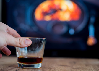 glass of rum before fireplace on mountains