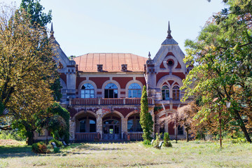 Taul Park, alley with benches, old ruined entrance main red building, north of Moldova