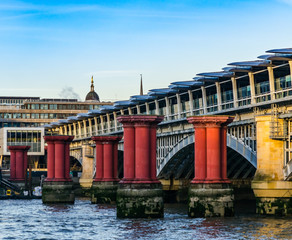 red columns in the water against the background of a bridge in L