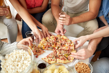 close up of people taking pizza slices at home