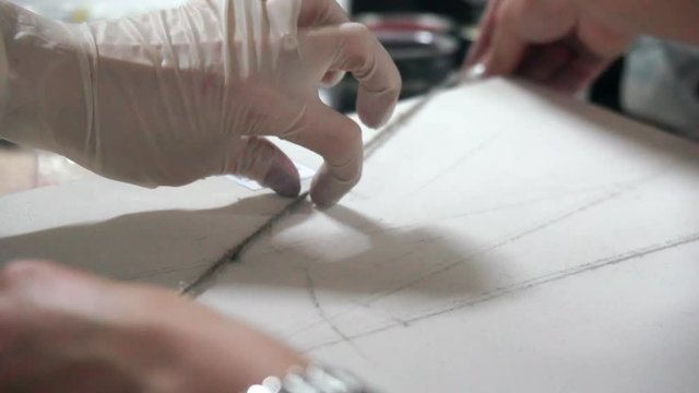 Designer decorates the paper using rope. Creative process in a professional design studio. Slow motion.