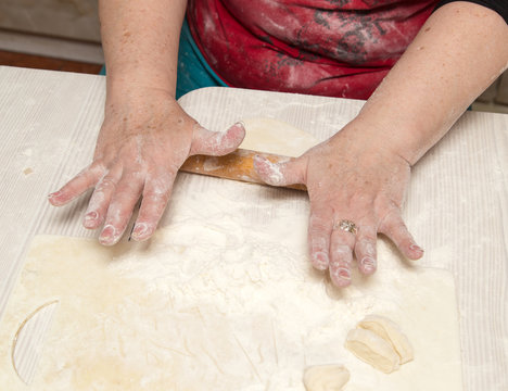 woman unrolls dough at home