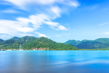Obraz premium Scenic view of the harbour with mountain background against cloudy sky at Bang-Bao Koh Chang Island, (Thailand).