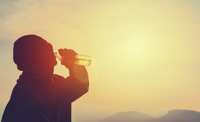 man drinking water on the hill