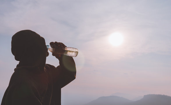 man drinking water on the hill
