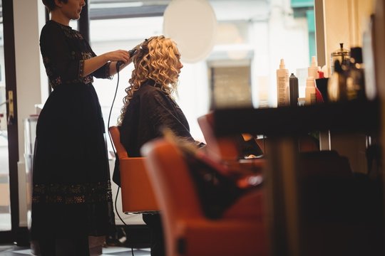 Female hairdresser styling clients hair