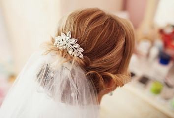 Bride is doing a hairstyle before the wedding