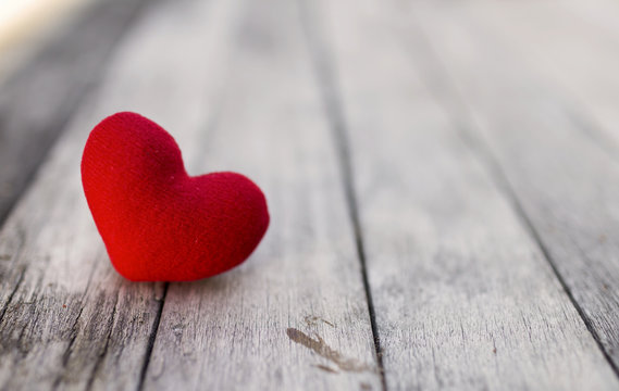 Red heart over blurred wood background, selective focus, valentine background