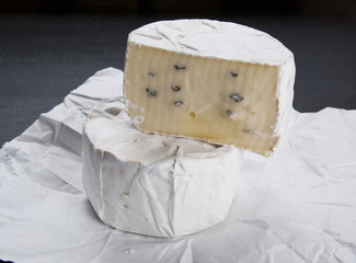 Soft cheese on white wrapping paper and black table