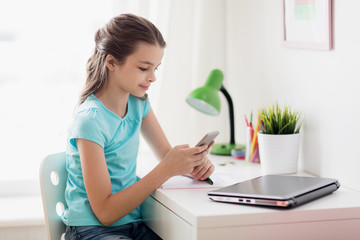 girl with laptop and smartphone texting at home