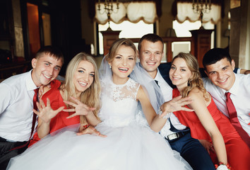 Cheerful young newlyweds with the friends in the hotel