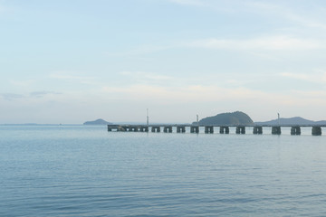 Long concrete jetty with islands and sky background