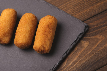 Croquettes on plate of slate seen from above. Horizontal shoot.