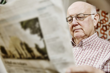 Senior liest eine Zeitung