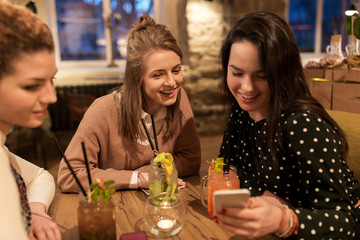 happy friends with drinks at restaurant