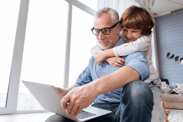 Handsome cheerful man holding a laptop