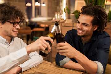 happy male friends drinking beer at bar or pub