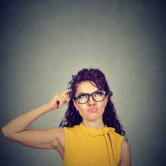 Confused skeptical woman thinking looking up