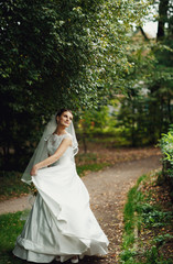Fototapeta premium wonderful young bride dances in a green garden