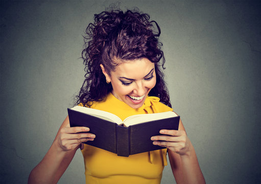 Happy young woman reading a book