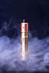 Electronic cigarette over a dark background. E-cigarette for vaping. Popular devices of the year....
