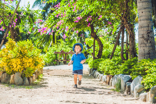 Boy runs through the tropical garden