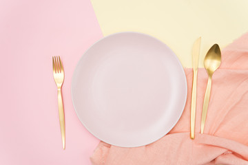 empty plate, fork, knife and spoon on table