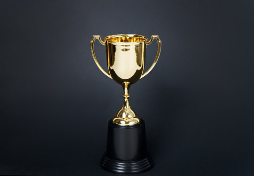 gold winner cup on black background