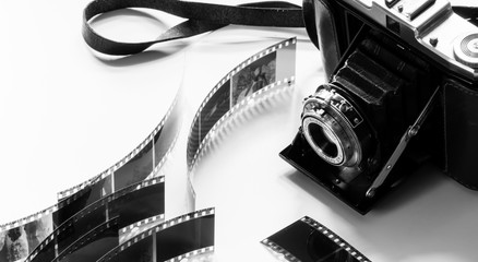 black and white photo of an old analogue camera displayed with negatives 