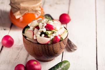 Salad with fresh vegetables and cottage cheese. Horizontal orientation. Wooden table